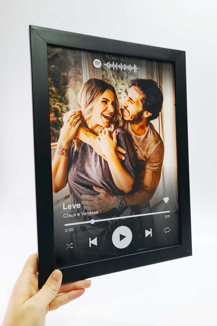 Digital photo frame displaying a couple embracing with music player interface.