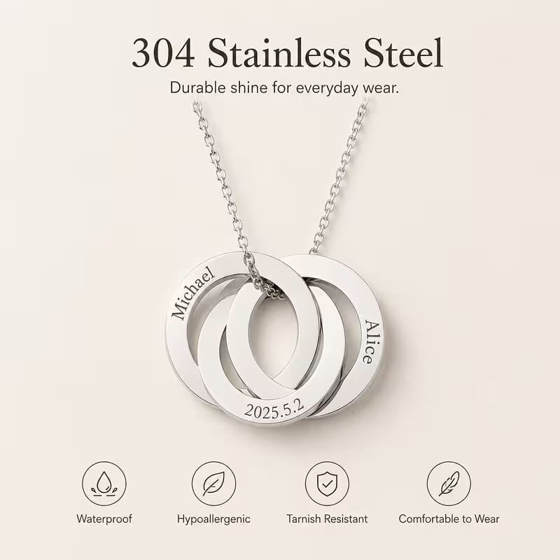 A silver stainless steel pendant necklace with three interlocking circular tags on a chain, shown on a light beige background with text reading '304 Stainless Steel' and feature icons below.