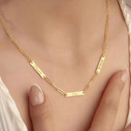 Gold necklace with engraved names on a person's neck